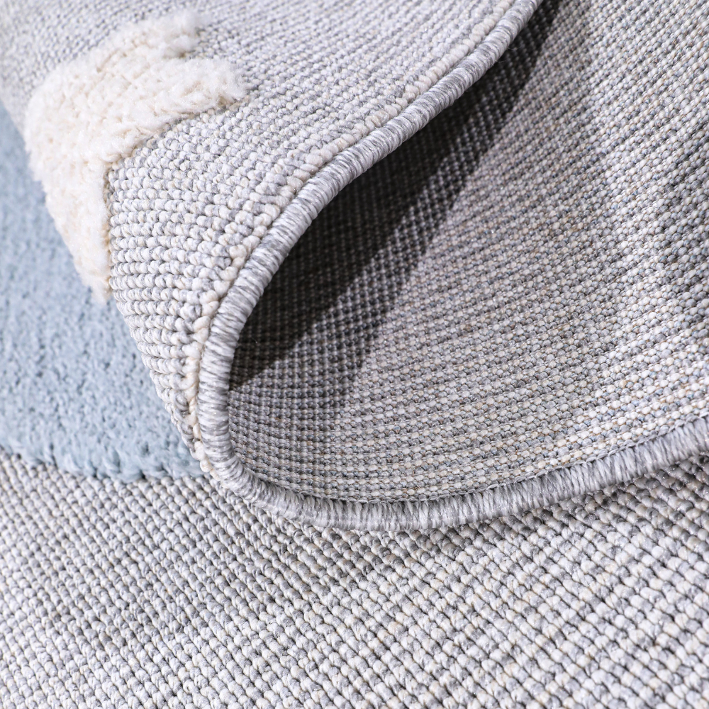 Soft, textured kids woven rug featuring crescent moon and star designs in gray.