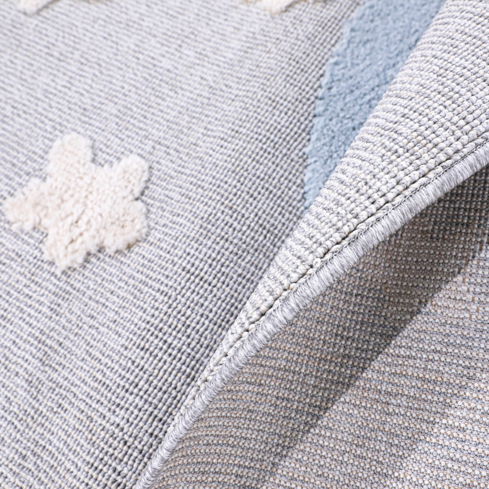 Textured kids rug with crescent moon and star motifs in soft gray and blue hues.