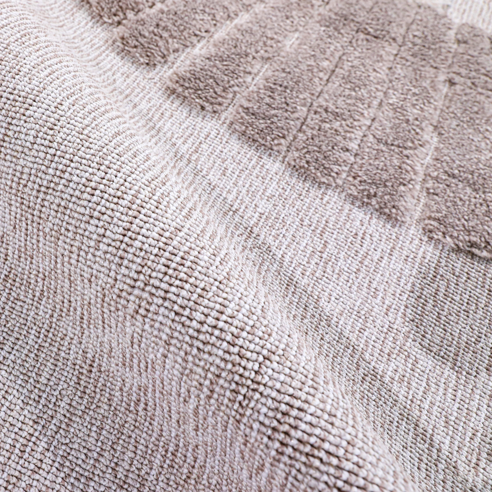 Detail of Distant Whispers Lion Woven Rug showcasing soft neutral textures.
